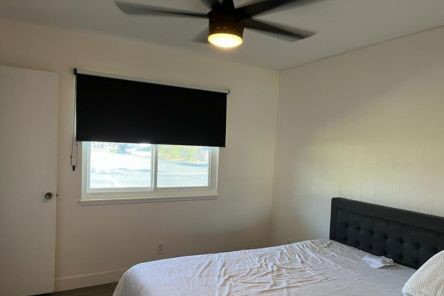 Custom blackout roller shades installed in a Pasadena bedroom, showcasing pull down window shades for total light control.
