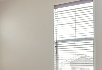 Empty living room remodeled with sleek horizontal faux wood blinds